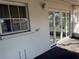 A covered patio features a white wall with windows and glass doors leading outside at 11470 88Th Ter, Seminole, FL 33772
