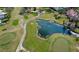 Aerial shot of a golf course with a pond and surrounding trees in a beautiful community at 1157 Woodleaf Ct, Palm Harbor, FL 34684