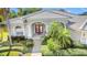 Inviting front entrance with lush landscaping and double red doors, tile roof and brick pathway at 13505 Woodside Dr, Hudson, FL 34667