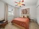 Bright bedroom showcasing a queen bed, ceiling fan, and a large window dressed with patterned curtains at 15720 Ibisridge Dr, Lithia, FL 33547