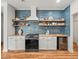 Stylish kitchen featuring wood floors, white cabinets, stainless steel appliances, and blue backsplash at 15720 Ibisridge Dr, Lithia, FL 33547