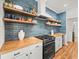 Modern kitchen with sleek countertops, floating shelves, and stainless steel appliances at 15720 Ibisridge Dr, Lithia, FL 33547