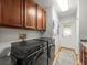Laundry area with washer and dryer, wood cabinets, and access to exterior door with decorative glass at 15720 Ibisridge Dr, Lithia, FL 33547