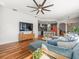 Open concept living room with hardwood floors, large sectional sofa, and adjacent kitchen and dining areas at 15720 Ibisridge Dr, Lithia, FL 33547