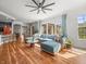 Open-concept living room with wood floors, a large sectional, and views into the kitchen and dining area at 15720 Ibisridge Dr, Lithia, FL 33547