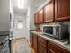 Hallway area with wood cabinets, microwave, grey counter top, and an exterior door with decorative glass at 15720 Ibisridge Dr, Lithia, FL 33547