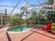 Outdoor pool with a screened enclosure, red chairs, and ample deck space at 15720 Ibisridge Dr, Lithia, FL 33547