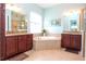 Primary bathroom showcasing a soaking tub, dual vanities, and tile floors at 1605 Emerald Dunes Dr, Sun City Center, FL 33573