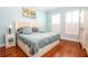 A serene bedroom with light blue walls, hardwood floors, plantation shutters, and beach-themed decor at 1605 Emerald Dunes Dr, Sun City Center, FL 33573