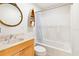 Bright bathroom featuring a tub with shower, stylish mirror, and boat-shaped shelving at 2003 Mcmullen Ave, Dunedin, FL 34698