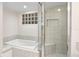 Bathroom featuring a soaking tub next to a glass shower and a glass block window at 2003 Mcmullen Ave, Dunedin, FL 34698