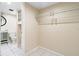 Spacious walk-in closet with built-in shelving, adjacent to bathroom with modern fixtures at 2003 Mcmullen Ave, Dunedin, FL 34698