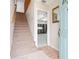 Inviting entryway with a staircase, light tile floors, and a view into a workshop or garage at 2003 Mcmullen Ave, Dunedin, FL 34698