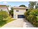 Exterior elevation view of the home featuring a large driveway and blue garage door at 2003 Mcmullen Ave, Dunedin, FL 34698