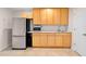 Kitchenette featuring stainless steel refrigerator and light wood cabinets at 2003 Mcmullen Ave, Dunedin, FL 34698