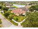Aerial view of a beige two-story home with a tile roof, three-car garage, and nearby pond at 2604 Dakota Rock Dr, Ruskin, FL 33570