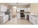 Bright kitchen featuring white cabinetry, stainless steel appliances, and tile flooring at 2604 Dakota Rock Dr, Ruskin, FL 33570