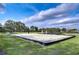 Outdoor sand volleyball court surrounded by grassy fields and blue skies with clouds creating a vibrant community space at 31132 Masena Dr, Wesley Chapel, FL 33545