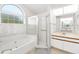 Bathroom featuring soaking tub under window and separate glass-enclosed shower and vanity sink at 3414 Shady Brook Ln, Sarasota, FL 34243