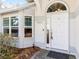Close-up of the front door with an arched window above and manicured landscaping at 3414 Shady Brook Ln, Sarasota, FL 34243