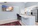 Open concept kitchen with stainless steel appliances, white cabinetry, and breakfast bar seating at 3414 Shady Brook Ln, Sarasota, FL 34243