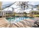 This covered pool overlooks a lake in the distance at 3414 Shady Brook Ln, Sarasota, FL 34243