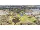 Aerial view of community featuring a golf course, ponds, mature trees, and residential homes at 36645 Kay Ave, Zephyrhills, FL 33542