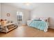 Bright bedroom with wood-look floors, a window, and a comfortable bed at 36645 Kay Ave, Zephyrhills, FL 33542