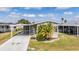 Charming home with covered parking, featuring mature palm trees and a well-maintained front yard at 36645 Kay Ave, Zephyrhills, FL 33542