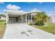 Charming home with covered parking, featuring mature palm trees and a well-maintained front yard at 36645 Kay Ave, Zephyrhills, FL 33542