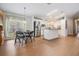 Open concept kitchen and dining area with wood laminate floors and stainless steel refrigerator at 36645 Kay Ave, Zephyrhills, FL 33542