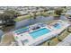 Aerial view of a community pool area with two pools, hot tub, lounge chairs, outdoor bar, and a waterway at 36645 Kay Ave, Zephyrhills, FL 33542