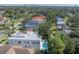 Areal view of a modern home with a pool, surrounded by lush greenery and neighborhood at 4110 W Swann Ave, Tampa, FL 33609