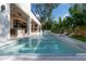 Backyard oasis featuring a modern pool, outdoor kitchen, and lush landscaping at 4110 W Swann Ave, Tampa, FL 33609