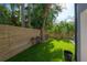 Lush backyard with artificial turf, mature trees, a wooden fence, and bar seating at 4110 W Swann Ave, Tampa, FL 33609