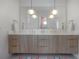 Modern bathroom features a long double vanity with brass fixtures, pendant lighting, and stylish decor at 4110 W Swann Ave, Tampa, FL 33609