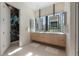 Bathroom featuring double sinks, large windows with exterior views and decorative wall art at 4110 W Swann Ave, Tampa, FL 33609