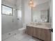 Stylish bathroom with a glass-enclosed shower, a modern vanity, and two decorative pendant lights at 4110 W Swann Ave, Tampa, FL 33609