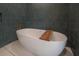 Freestanding bathtub with a wooden bath tray, set against a backdrop of sleek, modern tiles at 4110 W Swann Ave, Tampa, FL 33609