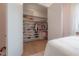 Open walk-in closet featuring custom shelving and a variety of hanging clothes and accessories in bedroom at 4110 W Swann Ave, Tampa, FL 33609