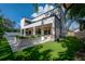 Modern home exterior with a covered patio, landscaped planters, and artificial turf at 4110 W Swann Ave, Tampa, FL 33609