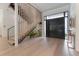 Inviting entryway with light wood floors, modern staircase, and a stylish black front door at 4110 W Swann Ave, Tampa, FL 33609