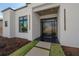 Close-up of the modern home's front entrance featuring a stylish door and minimalist design at 4110 W Swann Ave, Tampa, FL 33609