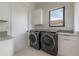 Functional laundry room with modern washer and dryer, cabinetry, and natural light at 4110 W Swann Ave, Tampa, FL 33609