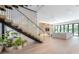 Open-concept living area with a modern staircase, sleek built-ins, and large windows offering backyard views at 4110 W Swann Ave, Tampa, FL 33609
