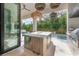 View of outdoor kitchen featuring island, stainless appliances, and backyard pool at 4110 W Swann Ave, Tampa, FL 33609