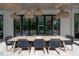 Covered outdoor patio with a dining table, chairs, and unique woven pendant lighting at 4110 W Swann Ave, Tampa, FL 33609