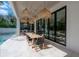 A covered patio featuring wicker lights, a dining table, and an outdoor kitchen at 4110 W Swann Ave, Tampa, FL 33609