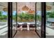 Outdoor dining area with modern table and chairs, wicker lights, and pool view at 4110 W Swann Ave, Tampa, FL 33609