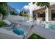 Relaxing poolside with stylish lounge chairs, a modern outdoor kitchen, and serene landscaping at 4110 W Swann Ave, Tampa, FL 33609